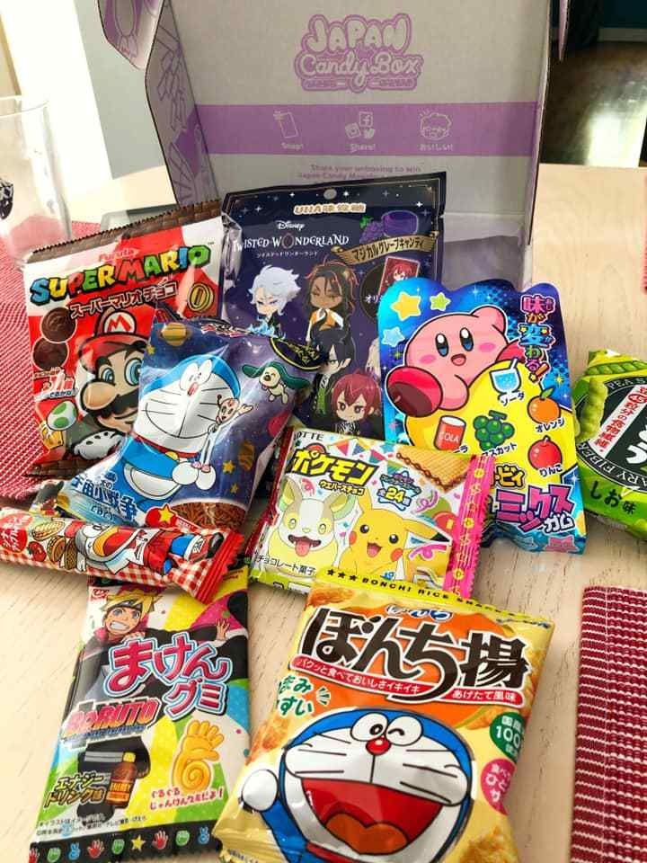 various japanese snacks are on the table next to each other in front of an open box