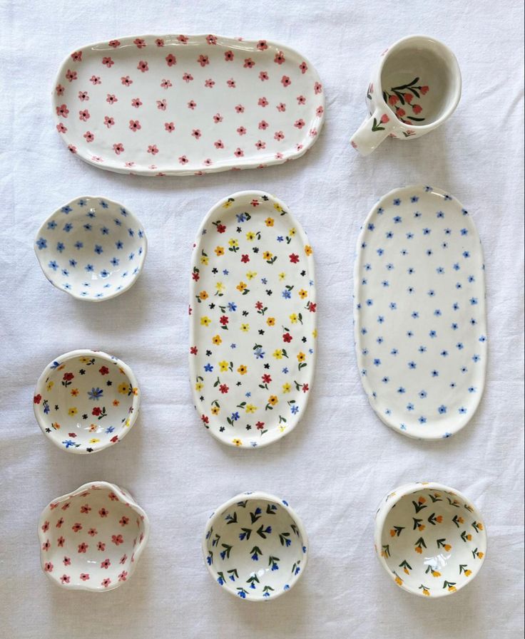 six different types of dishes and cups on a white tablecloth with polka dot designs