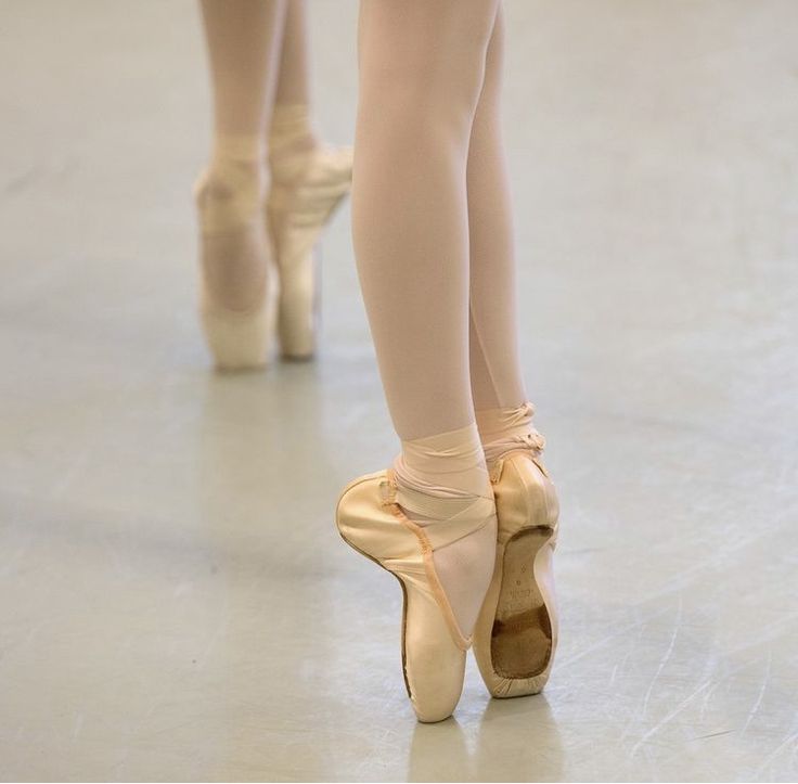 the legs and feet of two ballerinas in ballet shoes