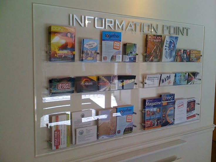 there are many books on display in the glass case that says information point, and it is white with silver lettering