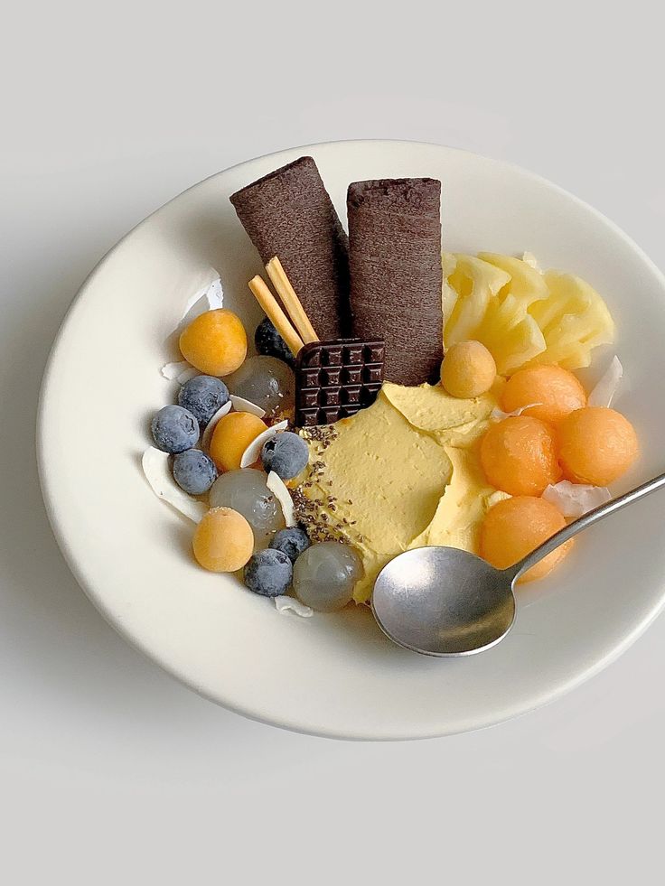 a white plate topped with different types of food and a spoon on top of it