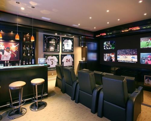 a sports themed home bar with seats and televisions