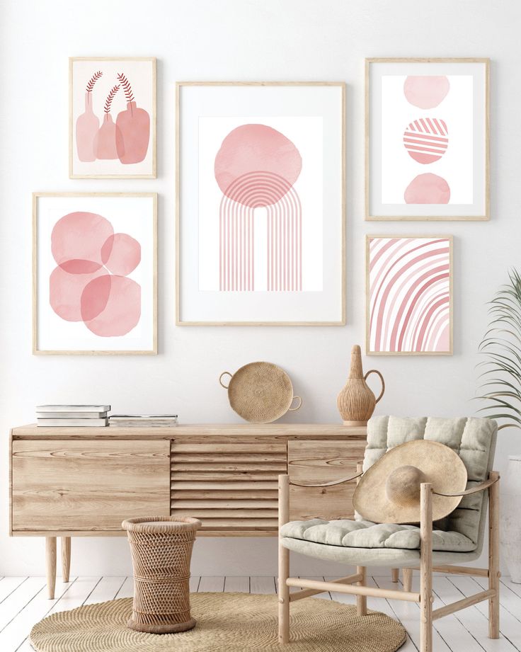 a living room with pink and white art on the wall, a chair, table and vase