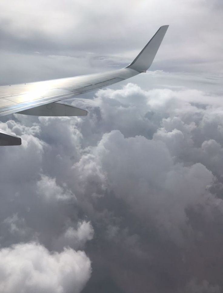 the wing of an airplane flying over clouds