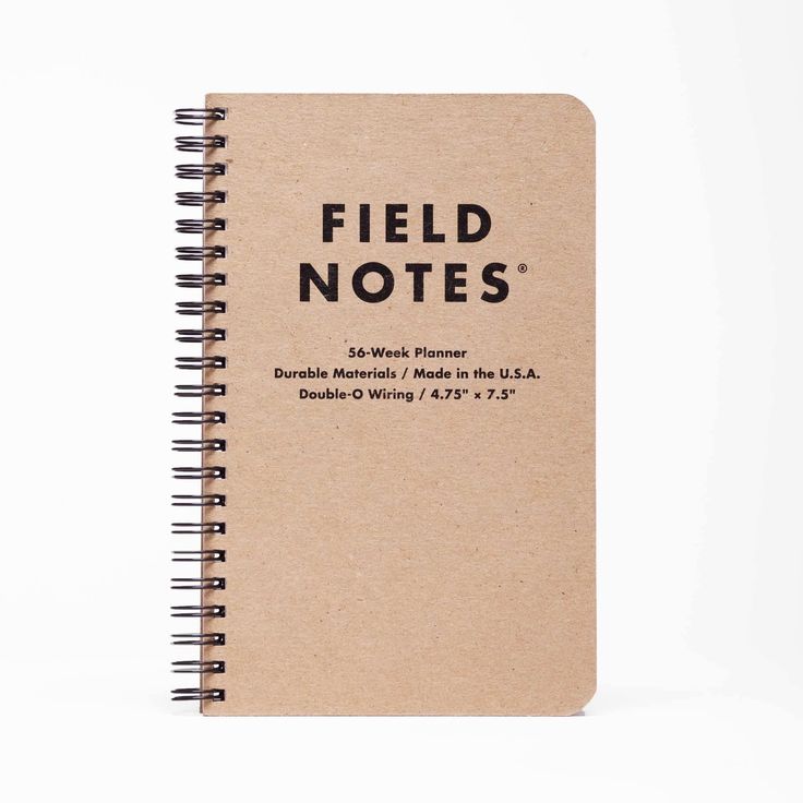 a spiral notebook with the words field notes written on it in black ink, sitting against a white background