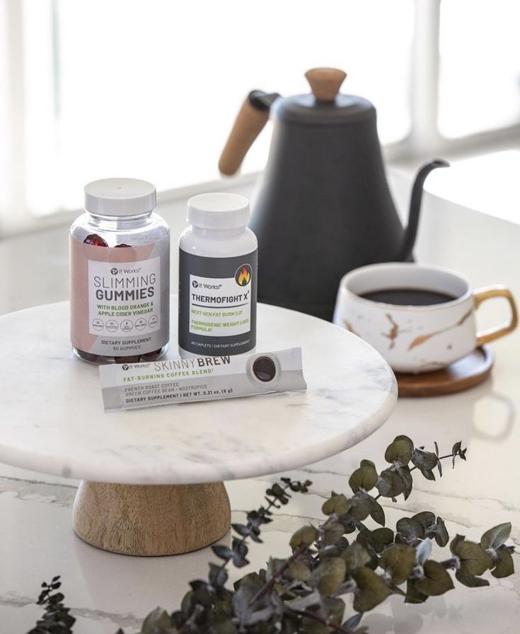 two bottles of vitamins sitting on top of a table next to a cup of coffee