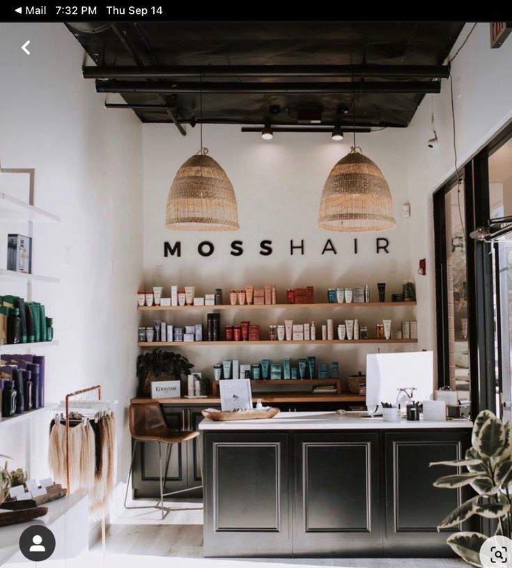 the interior of a hair salon with two hanging lamps