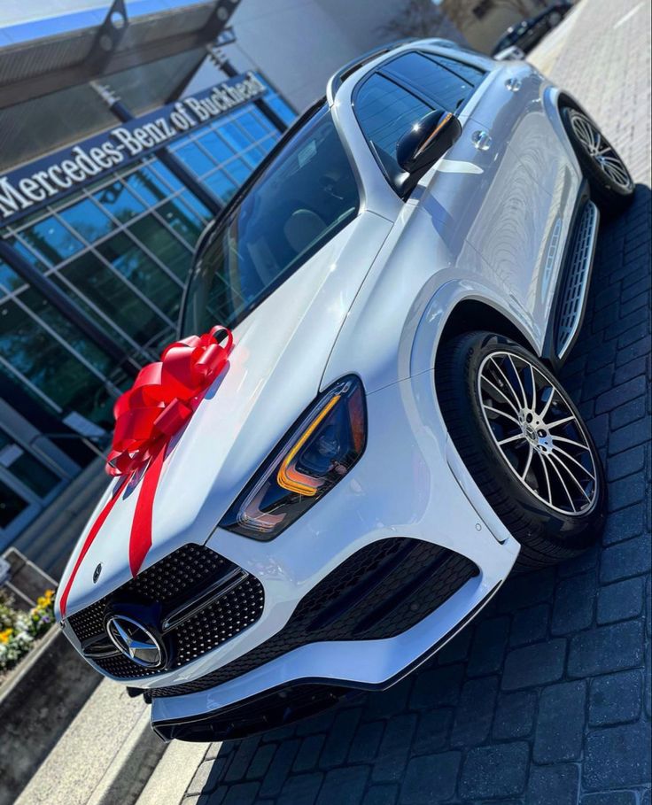 a white car with a red ribbon tied around it