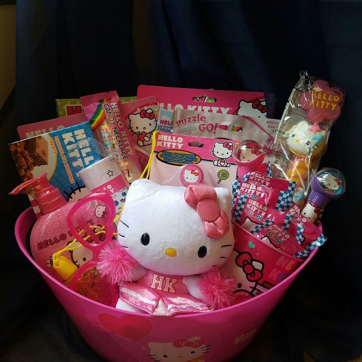 a pink hello kitty gift basket filled with candy, candies and other items in it