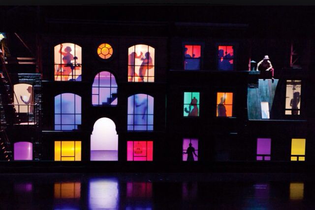 the stage is lit up with brightly colored windows and people standing on top of it