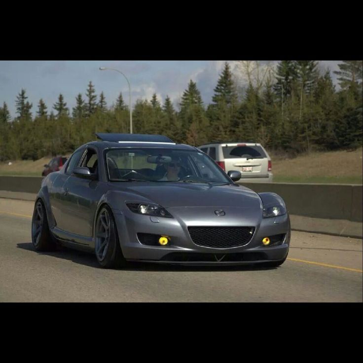 a gray sports car driving down the road