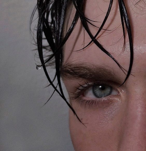 a man with wet hair and blue eyes