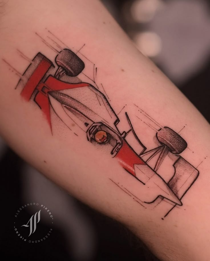 a tattoo with a drawing of a race car on it's left arm and red tape around the wrist