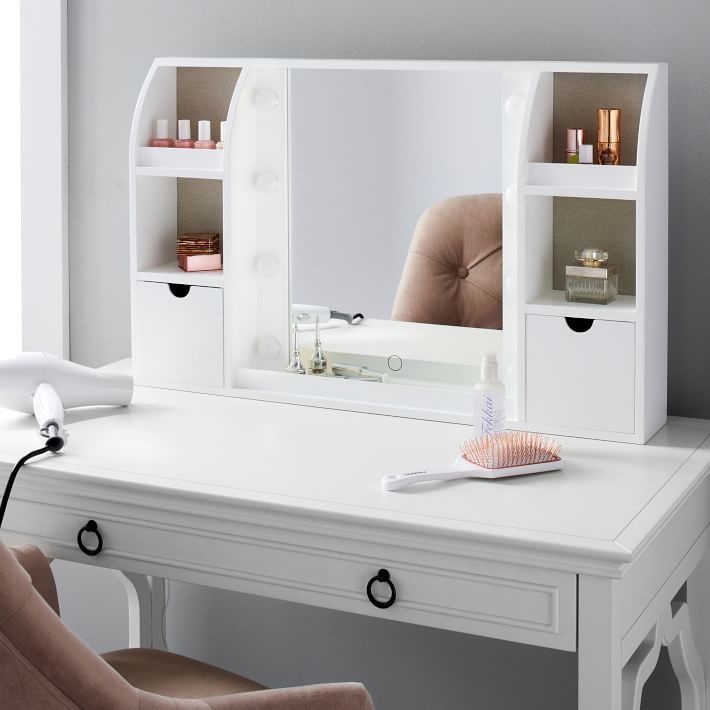 a white desk with a mirror and lights on top of it next to a chair