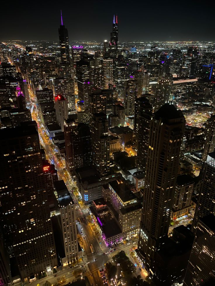 an aerial view of the city lights at night from high up in the skyscrapers