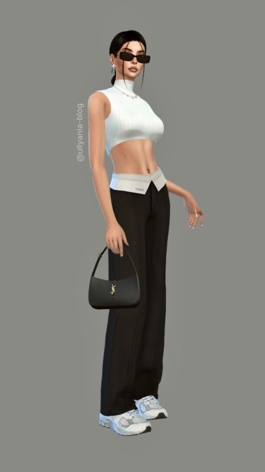 a woman in white top and black pants holding a handbag with her right arm