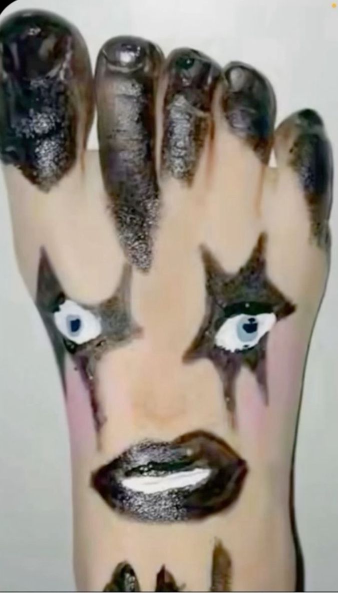 a person with makeup on their face and hands