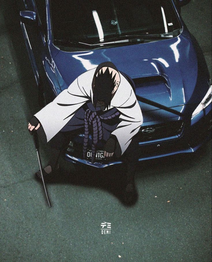 a man kneeling on the ground next to a blue car with a shark head painted on it