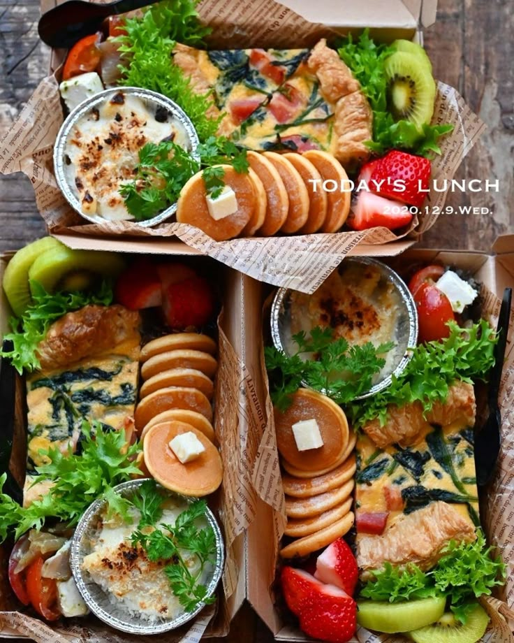 two boxes filled with different types of food on top of each other, including fruit and crackers