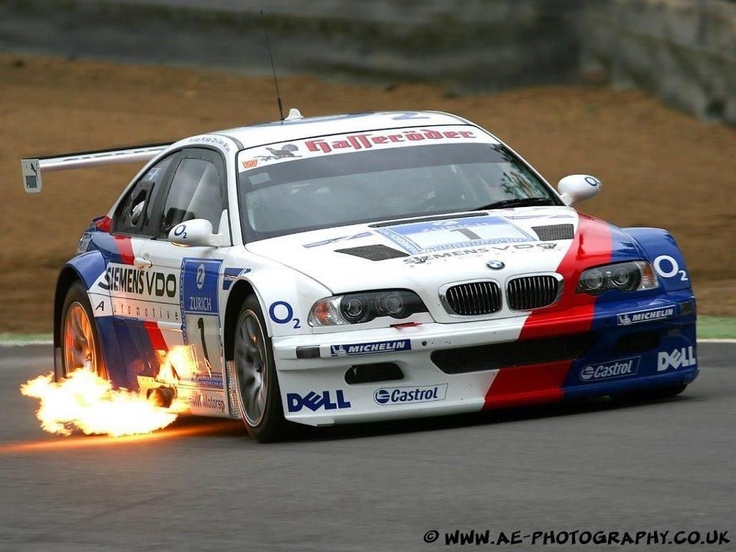 a bmw race car with flames coming out of it's tires