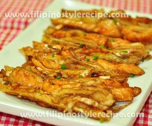 some fried food on a white plate on a red and white checkered table cloth