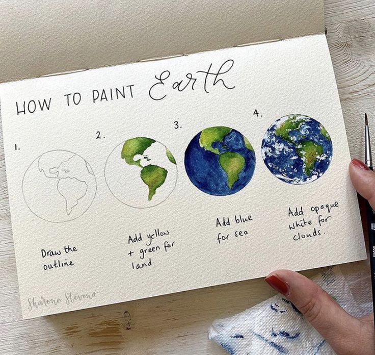 a person holding a piece of paper with watercolors on it and the words how to paint earth