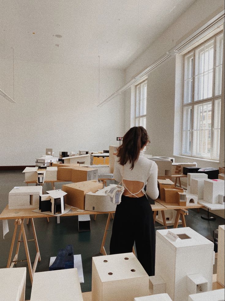 a woman standing in an empty room surrounded by boxes