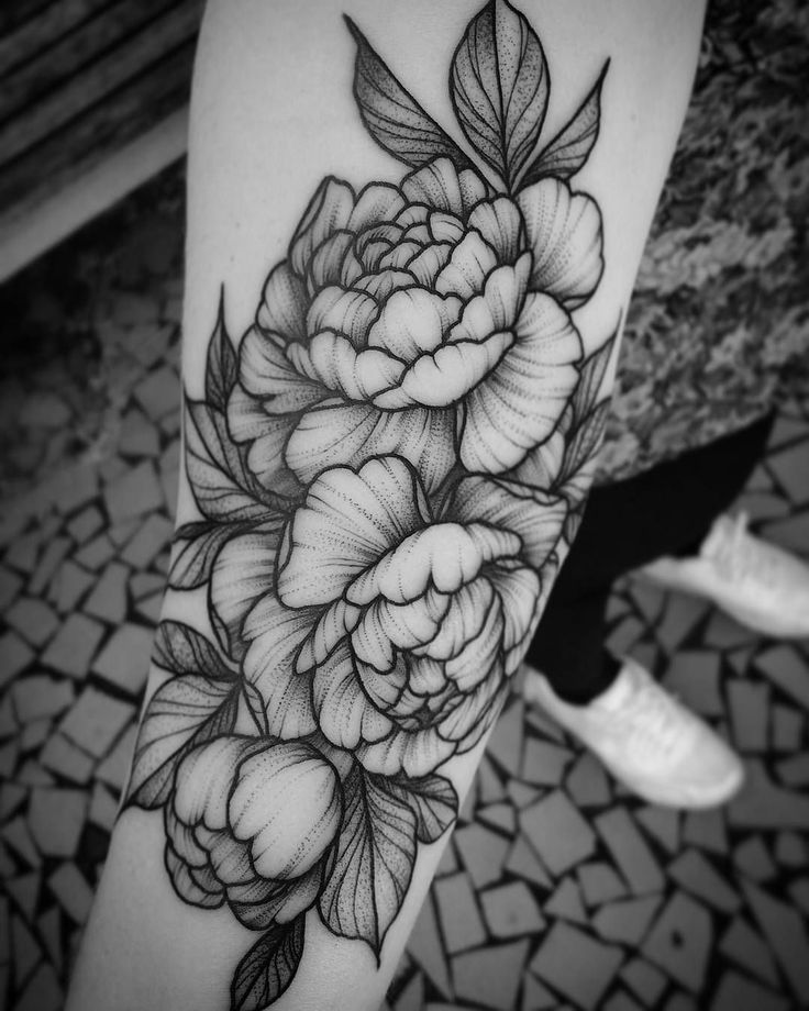 a black and white flower tattoo on the leg