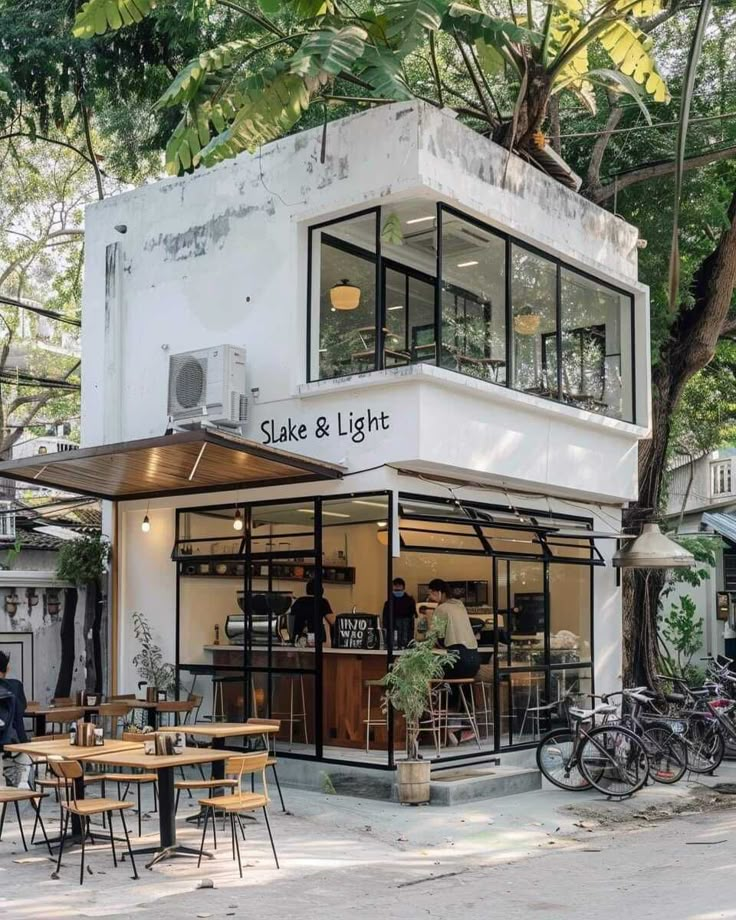 the outside of a restaurant with tables and bikes parked on the street in front of it