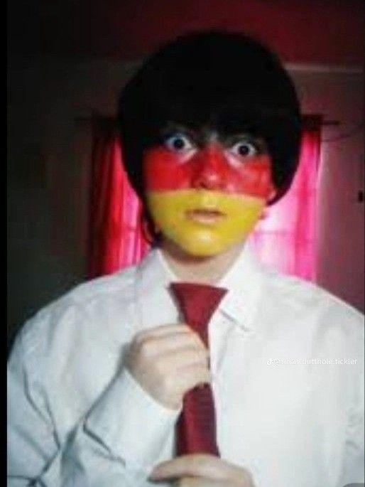 a man wearing a red tie and white shirt with his face painted like a german flag