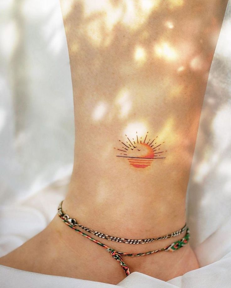 a woman's foot with a small sun tattoo on the side of her ankle