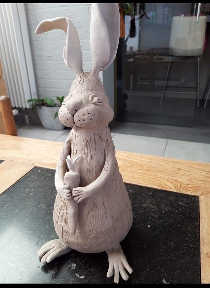 a clay sculpture of a rabbit sitting on top of a table