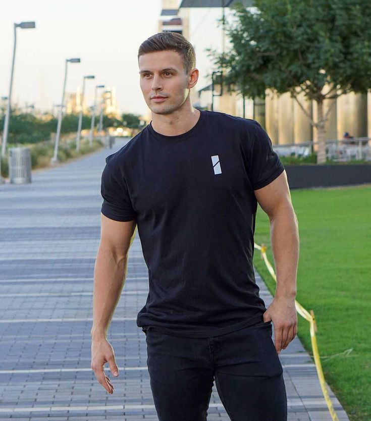 a man standing on the sidewalk with his skateboard