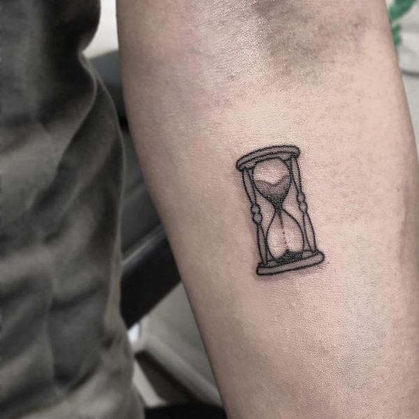 a small hourglass tattoo on the arm