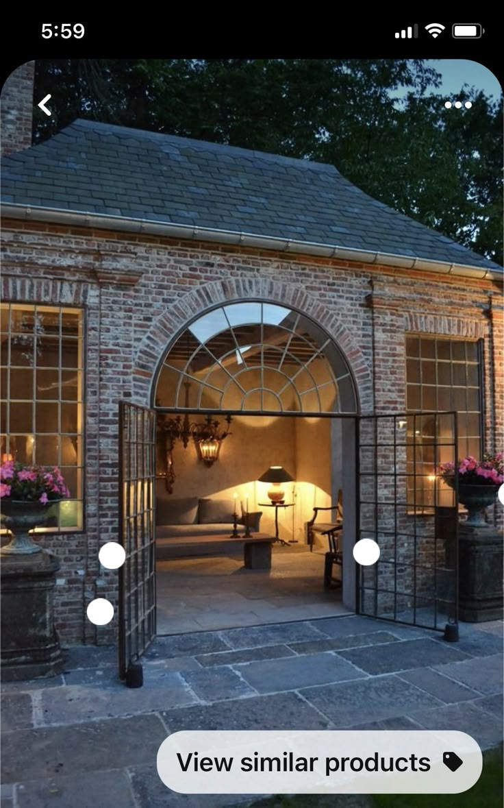 a brick building with an arched doorway and glass doors leading into the living room area