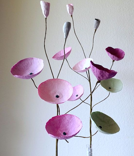 a vase filled with paper flowers on top of a table