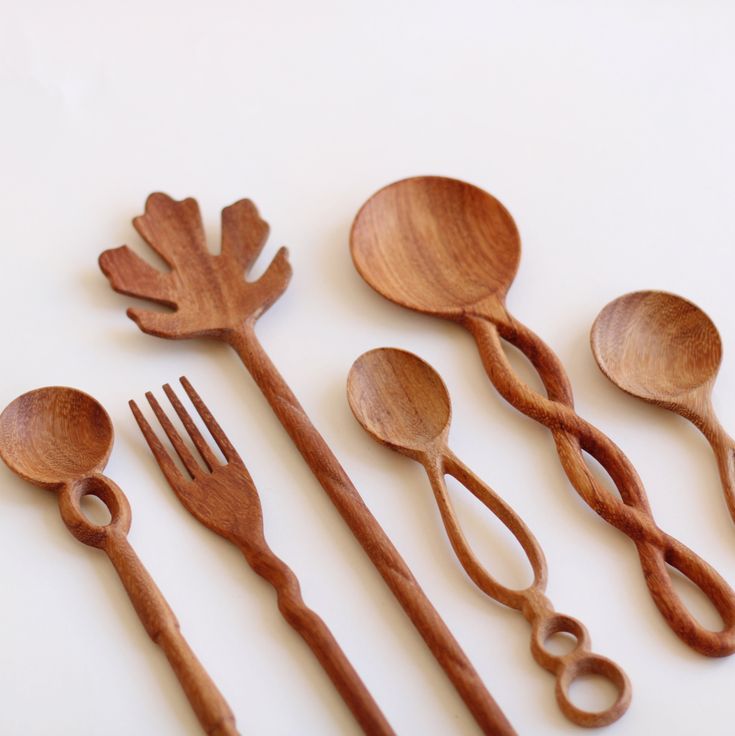 wooden utensils and spoons lined up on a white surface