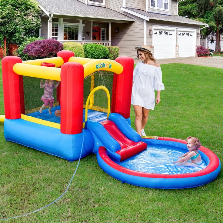 an inflatable bounce house with a toddler playing in the pool next to it