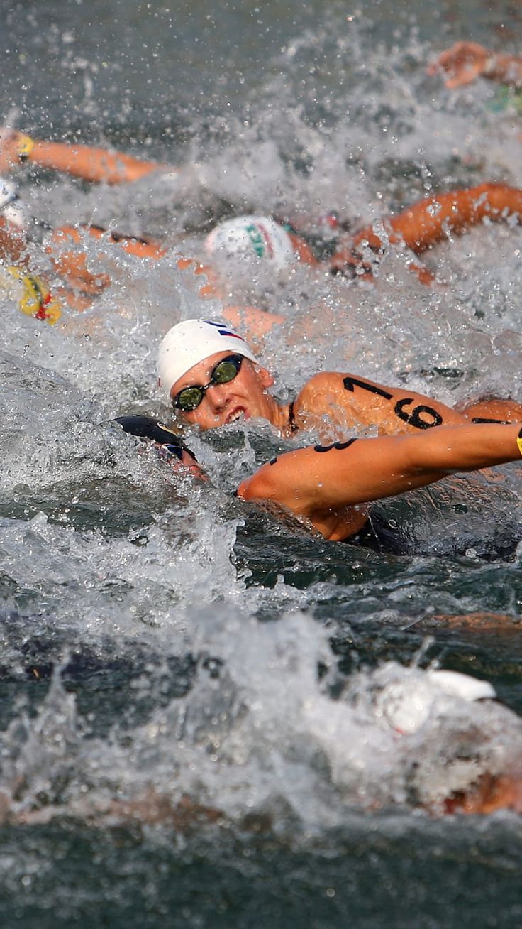 people swimming in the water with caps on