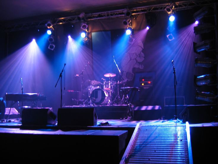 the stage is lit up with blue and purple lights as well as musical instruments on it