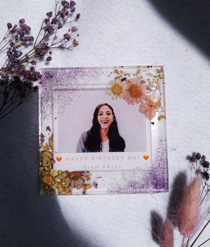 a birthday card featuring a photo of a woman with flowers on the table next to it