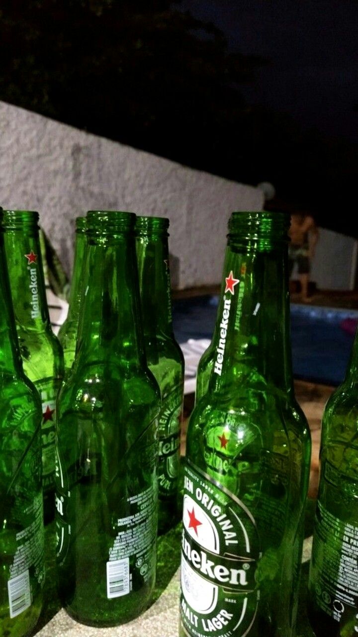 several green beer bottles lined up next to each other