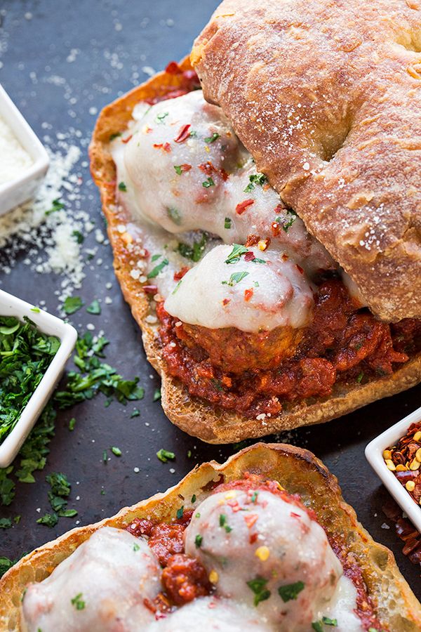 an open faced sandwich with meat and cheese on it, surrounded by other small dishes