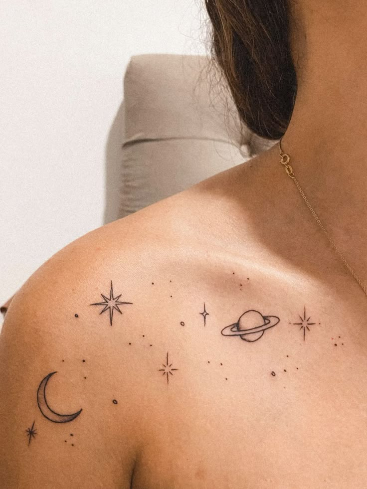 a woman's shoulder with stars and planets on it