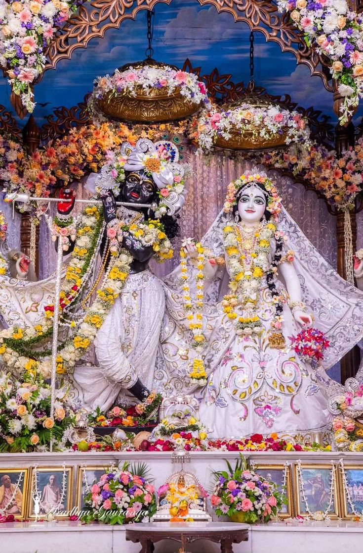 an idol is displayed in front of a stage with flowers and garlands on it