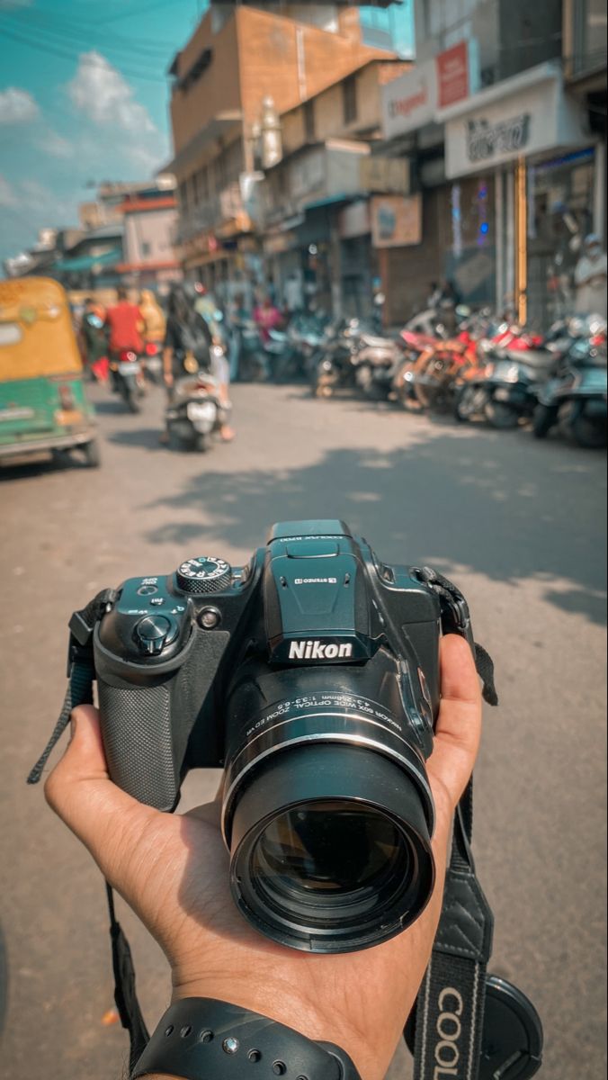 a person holding up a camera in the street