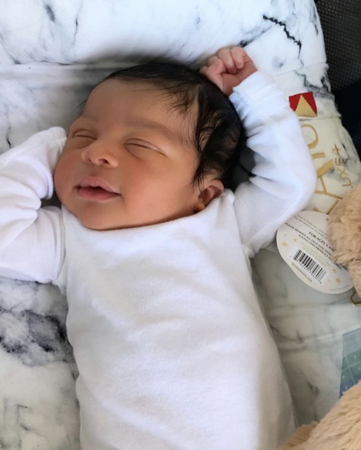 a baby is sleeping next to a teddy bear