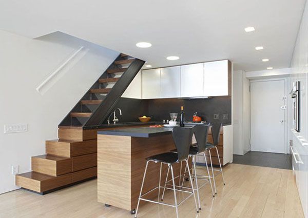 an open kitchen and dining area with stairs leading up to the upper floor in a modern home