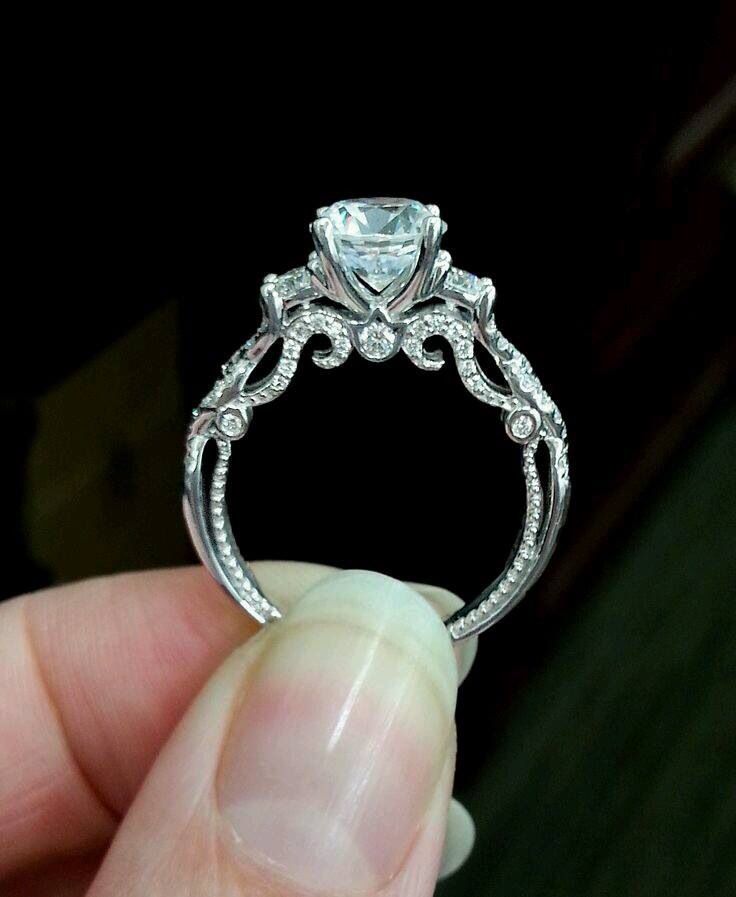 someone is holding an engagement ring that has been made with white gold and diamond accents