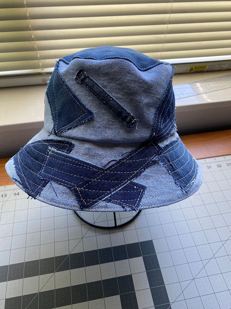 a blue jean hat sitting on top of a table next to a window sill